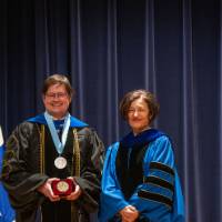 Provost smiles for picture with faculty